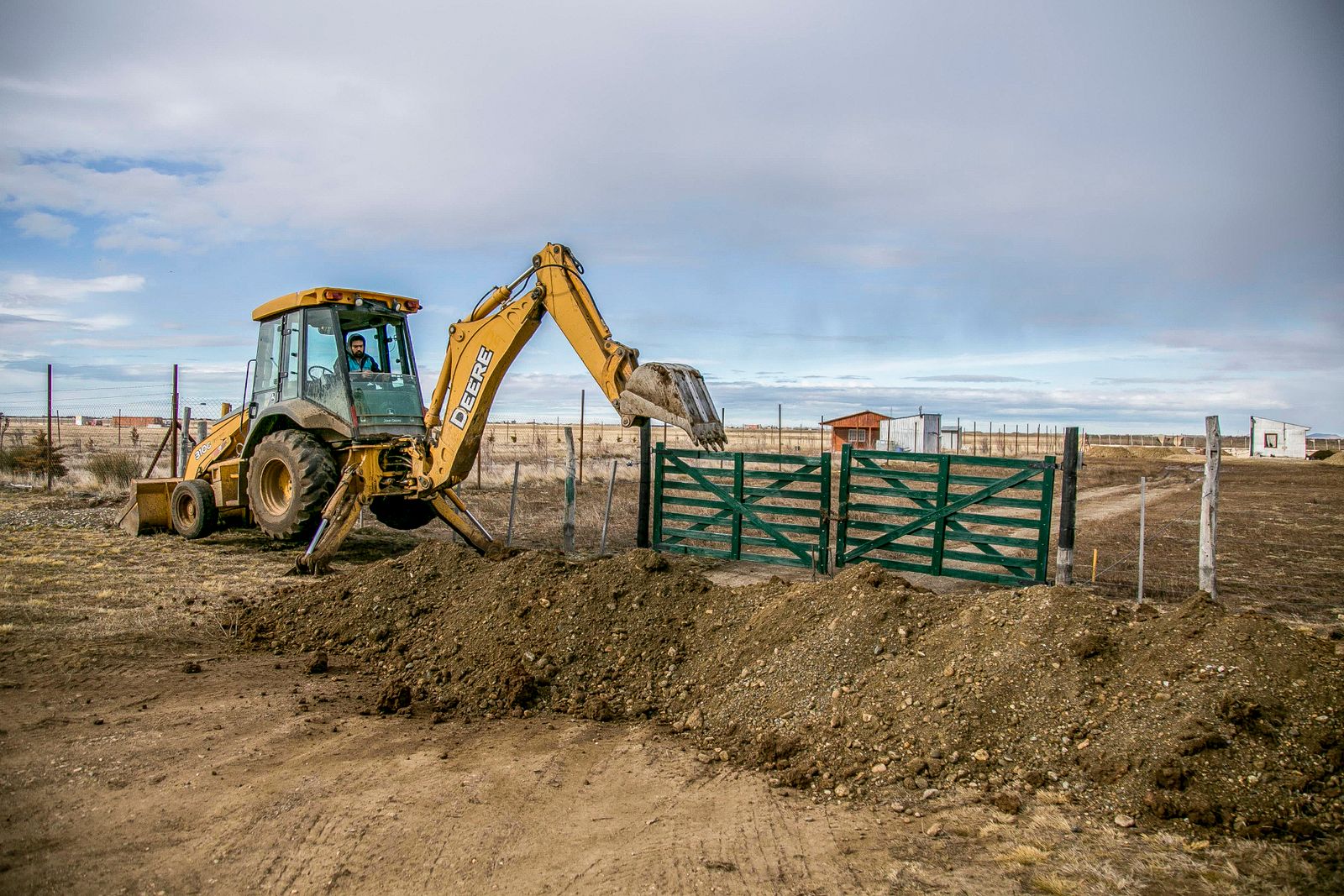 Backhoe digging in open ground on a rural property